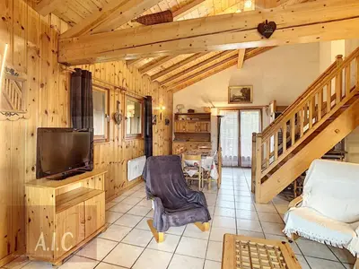 a living room with a staircase and a television at Grand Duplex 110m² 3 Chambres avec Balcon & Terrasse - FR-1-560-3 in Combloux