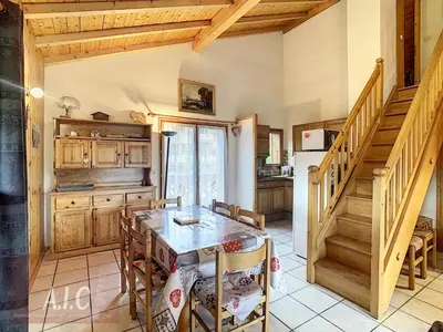 a kitchen with a table and chairs and a staircase at Grand Duplex 110m² 3 Chambres avec Balcon & Terrasse - FR-1-560-3 in Combloux