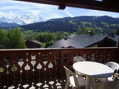 a balcony with a table and chairs and mountains at Grand Duplex 110m² 3 Chambres avec Balcon & Terrasse - FR-1-560-3 in Combloux