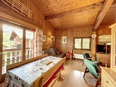 a room with a bed and a couch in a cabin at Appartement cosy à Combloux avec parking et cheminée - FR-1-560-9 in Combloux