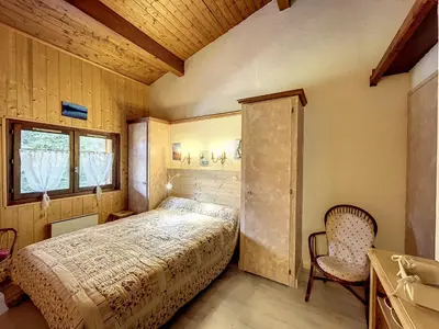 a bedroom with a bed and a window and a chair at Appartement cosy à Combloux avec parking et cheminée - FR-1-560-9 in Combloux