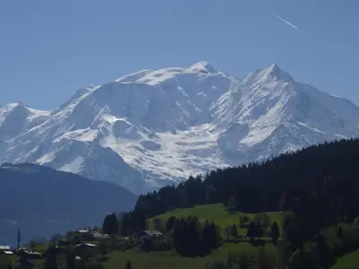 a snow covered mountain with a village in front at Appartement cosy à Combloux avec parking et cheminée - FR-1-560-9 in Combloux