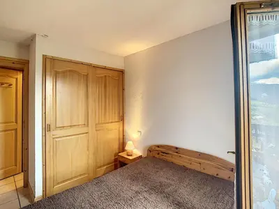 a bedroom with a bed and a sliding glass door at 3 pièces standing proche centre - Balcon Expo Est - FR-1-560-5 in Combloux
