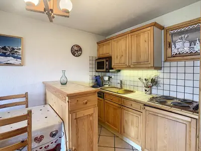 a kitchen with wooden cabinets and a sink at 3 pièces standing proche centre - Balcon Expo Est - FR-1-560-5 in Combloux