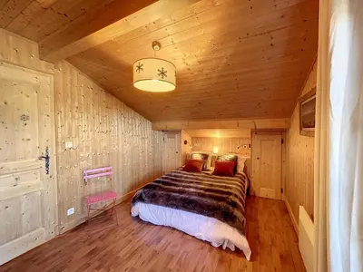 a bedroom with a bed in a wooden room at Demi-chalet duplex proche télécabine avec WiFi - FR-1-560-6 in Combloux