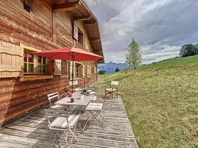 a patio with a table and chairs and an umbrella at Demi-chalet duplex proche télécabine avec WiFi - FR-1-560-6 in Combloux