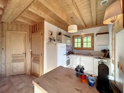 a kitchen with a white refrigerator and wooden ceilings at Demi-chalet duplex proche télécabine avec WiFi - FR-1-560-6 in Combloux
