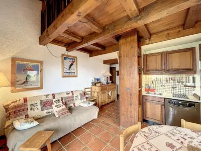 a living room with a couch and a kitchen at Charmant duplex près du téléski du Bouchet, idéal pour famille - FR-1-560-11 in Combloux