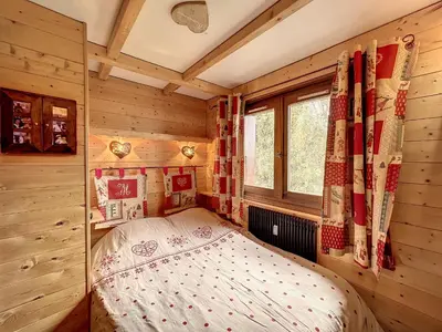 a bedroom with a bed in a wooden room at Charmant duplex près du téléski du Bouchet, idéal pour famille - FR-1-560-11 in Combloux