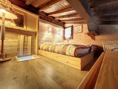 a bedroom with a bed in a log cabin at Charmant duplex près du téléski du Bouchet, idéal pour famille - FR-1-560-11 in Combloux
