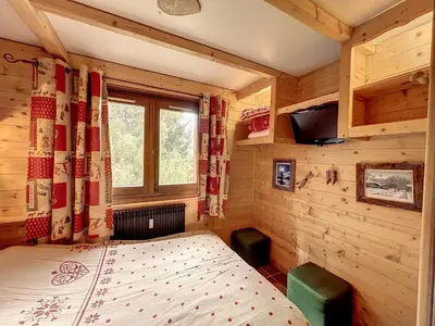 a bedroom with a bed in a wooden room at Charmant duplex près du téléski du Bouchet, idéal pour famille - FR-1-560-11 in Combloux