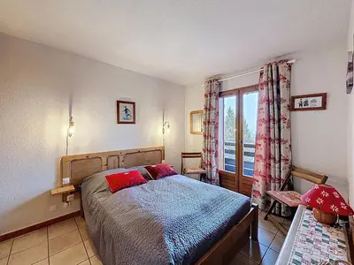 a bedroom with a bed and a large window at Appartement cosy 2 pièces à 2 pas des remontées mécaniques de Combloux - FR-1-560-20 in Combloux