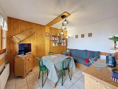 a living room with a table and a couch at Appartement cosy 2 pièces à 2 pas des remontées mécaniques de Combloux - FR-1-560-20 in Combloux