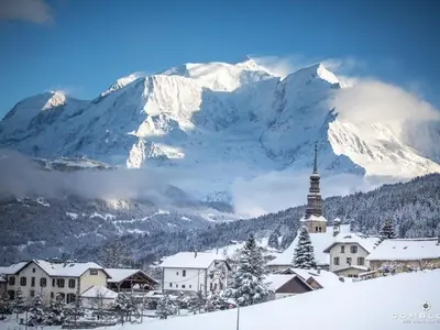 a snowy mountain range with a church and a village at Appartement cosy 2 pièces à 2 pas des remontées mécaniques de Combloux - FR-1-560-20 in Combloux