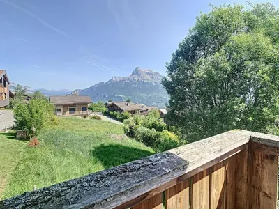 a house with a fence and a mountain in the background at Chalet 6 pièces à Combloux avec cheminée et parking - FR-1-560-21 in Combloux