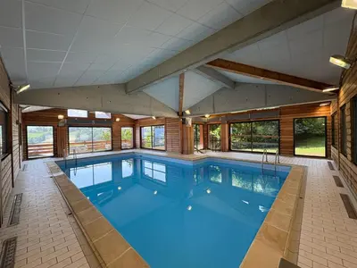an indoor swimming pool with a large room with windows at Chalet 6 pièces à Combloux avec cheminée et parking - FR-1-560-21 in Combloux