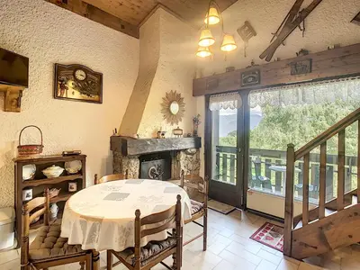 a dining room with a table and a fireplace at Duplex cosy 35m² près du centre de Combloux, face au Mont Blanc - FR-1-560-19 in Combloux