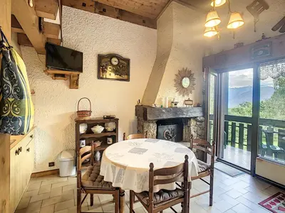 a dining room with a table and a fireplace at Duplex cosy 35m² près du centre de Combloux, face au Mont Blanc - FR-1-560-19 in Combloux