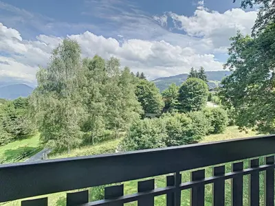 a balcony with a view of trees and a road at Duplex cosy 35m² près du centre de Combloux, face au Mont Blanc - FR-1-560-19 in Combloux