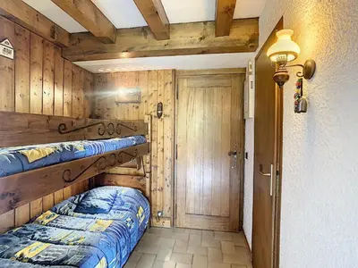 a bedroom with a bed and a wooden wall at Duplex cosy 35m² près du centre de Combloux, face au Mont Blanc - FR-1-560-19 in Combloux
