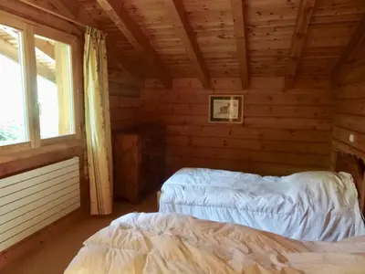 a bedroom with two beds in a log cabin at Grand chalet confortable à Demi-Quartier, 13 couchages - FR-1-560-36 in Demi-Quartier