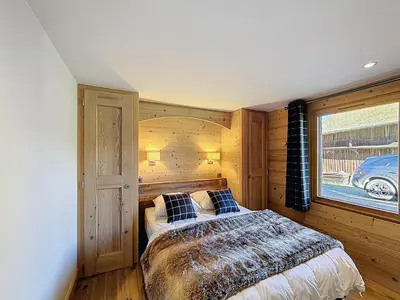 a bedroom with a bed and a window at Appartement 4P avec terrasse et vue Mont Blanc - FR-1-560-24 in Combloux