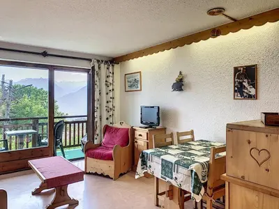 a bedroom with a bed and a television and a balcony at Studio agréable au centre de Combloux avec parking - FR-1-560-35 in Combloux