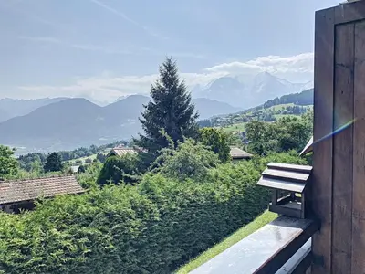 a bench sitting on a hill with a view of mountains at Studio agréable au centre de Combloux avec parking - FR-1-560-35 in Combloux