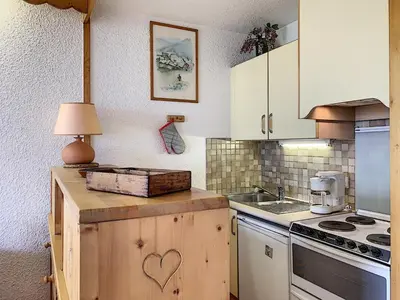 a kitchen with white cabinets and a table with a lamp at Studio agréable au centre de Combloux avec parking - FR-1-560-35 in Combloux