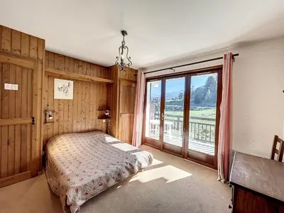 a bedroom with a bed and a large window at Appartement 3 pièces de charme aux pieds des pistes à Combloux - FR-1-560-28 in Combloux