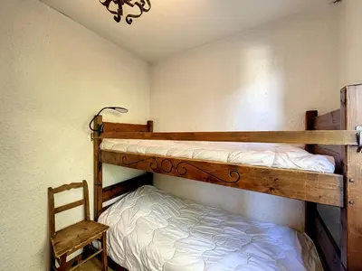 a bedroom with two bunk beds and a chair at Appartement 3 pièces de charme aux pieds des pistes à Combloux - FR-1-560-28 in Combloux