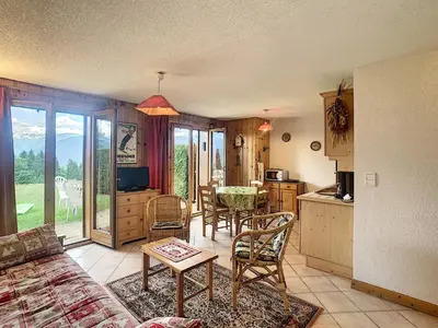 a living room with a table and chairs and a kitchen at Charmant 2 pièces cabine avec jardin, près de Combloux - FR-1-560-33 in Combloux