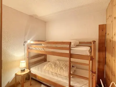 a bunk bed room with two bunk beds and a lamp at Charmant 2 pièces cabine avec jardin, près de Combloux - FR-1-560-33 in Combloux
