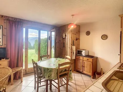 a kitchen with a table with chairs and a window at Charmant 2 pièces cabine avec jardin, près de Combloux - FR-1-560-33 in Combloux