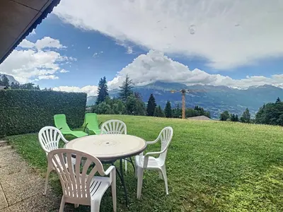 a table and chairs with a view of a mountain at Charmant 2 pièces cabine avec jardin, près de Combloux - FR-1-560-33 in Combloux