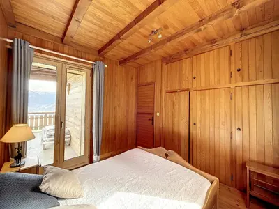 a bedroom with a bed and a large window at Chalet 8 couchages à Combloux, Hiver à la saison, Été à la semaine - FR-1-560-32 in Combloux