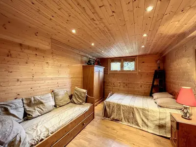 a room with two beds in a log cabin at Chalet 8 couchages à Combloux, Hiver à la saison, Été à la semaine - FR-1-560-32 in Combloux