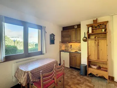 a kitchen with a table and a window at Studio cabine cosy proche du téléski - FR-1-560-40 in Combloux