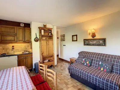 a living room with a couch and a kitchen at Studio cabine cosy proche du téléski - FR-1-560-40 in Combloux