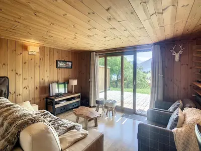 a living room with a couch and a tv in a room at 3 pièces, piscine intérieure, parking, proche centre à Combloux - FR-1-560-27 in Combloux