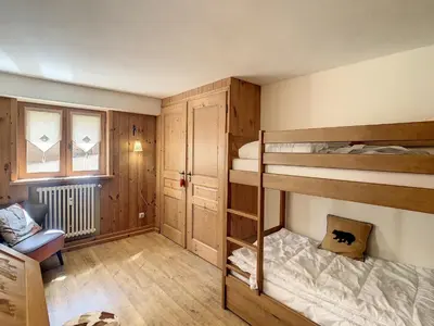 a room with two bunk beds and a chair at 3 pièces, piscine intérieure, parking, proche centre à Combloux - FR-1-560-27 in Combloux