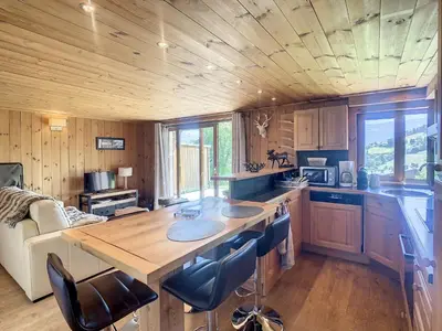a kitchen with a table and chairs in a cabin at 3 pièces, piscine intérieure, parking, proche centre à Combloux - FR-1-560-27 in Combloux