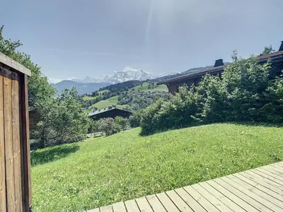 a view of a grassy hill with a house at 3 pièces, piscine intérieure, parking, proche centre à Combloux - FR-1-560-27 in Combloux