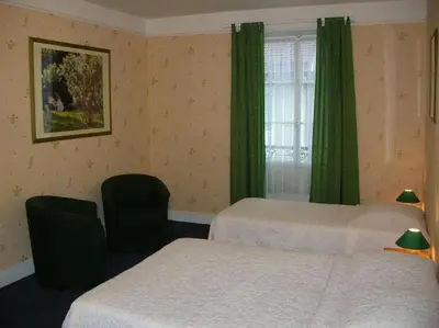 a hotel room with two beds and a window at Hotel du Mont Blanc in Sallanches