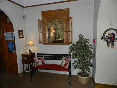 a living room with a bench and a mirror at Hotel du Mont Blanc in Sallanches