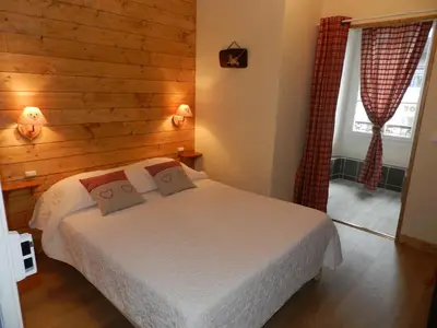 a bedroom with a bed with a wooden wall at Hotel du Mont Blanc in Sallanches