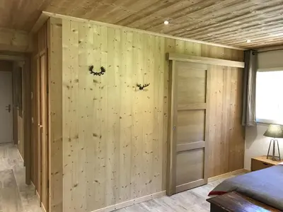 a bedroom with a wall of wood paneling at La Maison du Hérisson in Samoëns