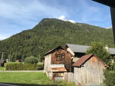 an old barn with a mountain in the background at La Maison du Hérisson in Samoëns