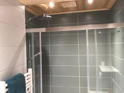 a shower with a glass door in a bathroom at La Maison du Hérisson in Samoëns