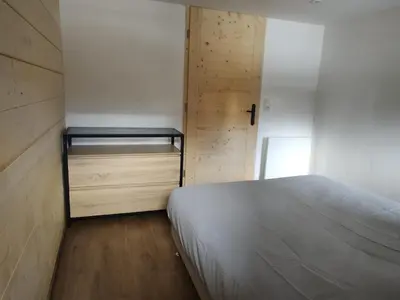a bedroom with a bed and a wooden wall at Chalet-Hôtel de l'Etape in Les Contamines-Montjoie